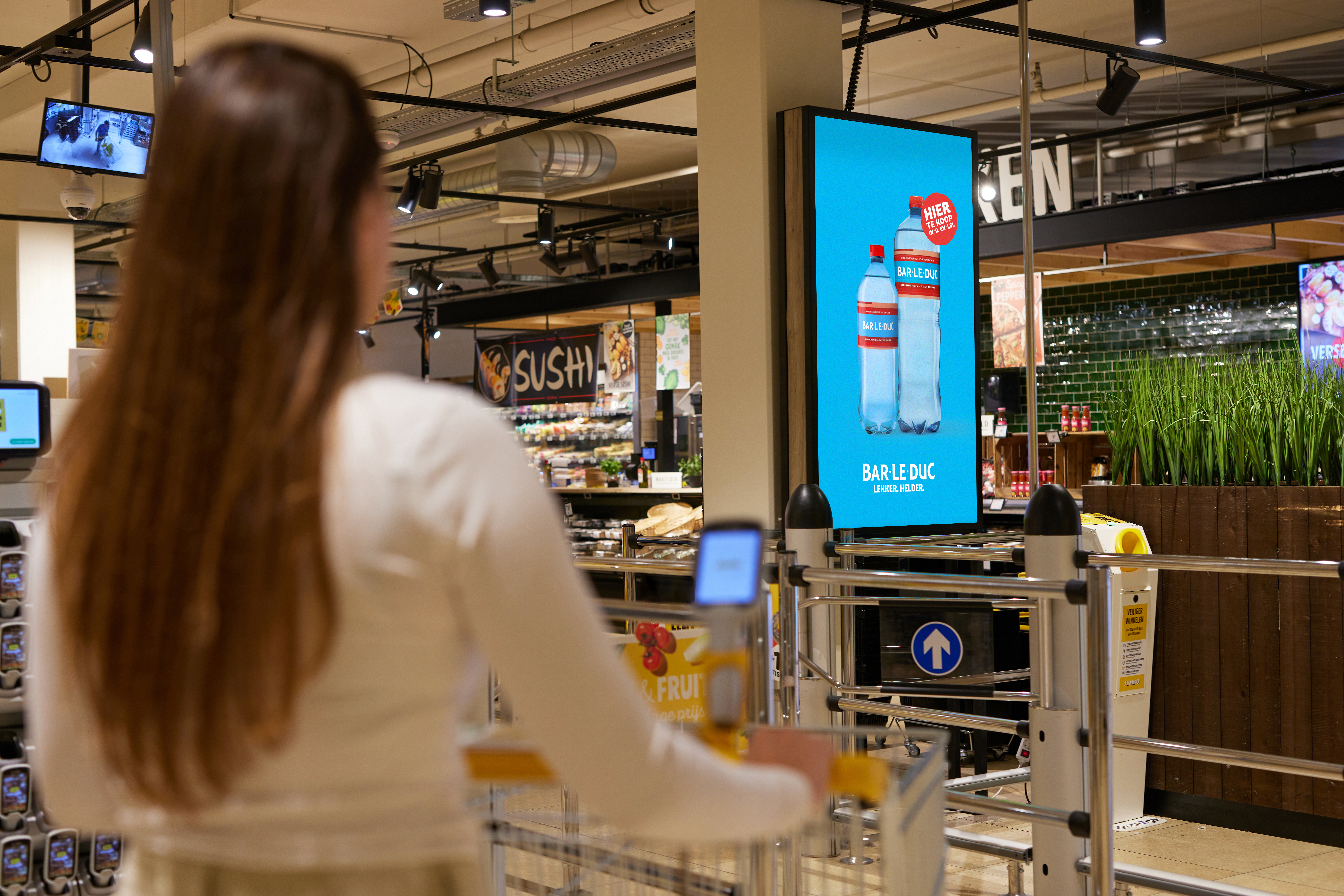 Vrouw in supermarkt met digital signage toepassingen